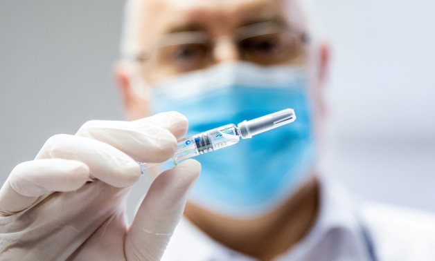 Doctor holding syring filled with vaccine - file