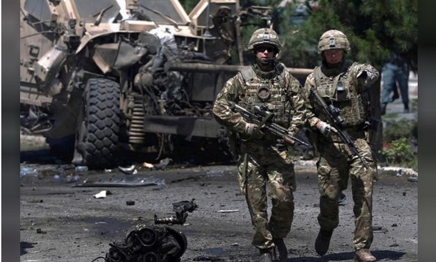 NATO soldiers walk at the site of a suicide bomb attack in Kabul, Afghanistan June 30, 2015. A suicide bomber attacked a convoy of foreign troops servin