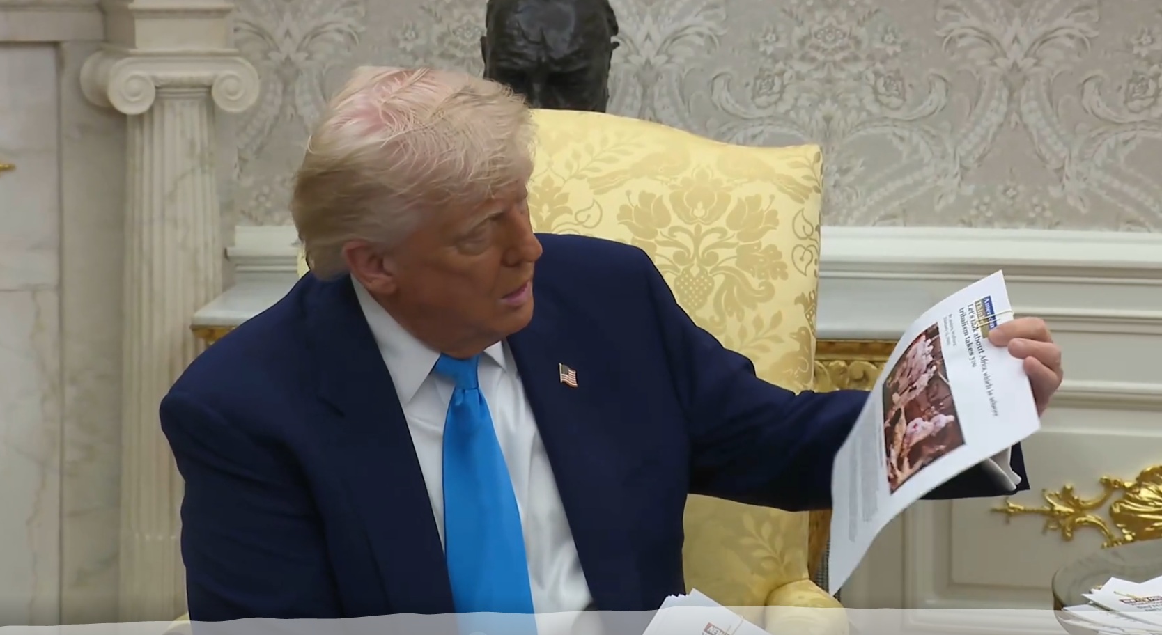 Le président américain Donald Trump affiche une capture d'écran d'une vidéo de Reuters prise dans le Dr Congo, affirmant à tort qu'elle montre des massacres d'agriculteurs blancs en Afrique du Sud
