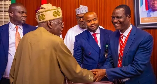 Tinubu shaking hands with Oyedele on tax reform laws