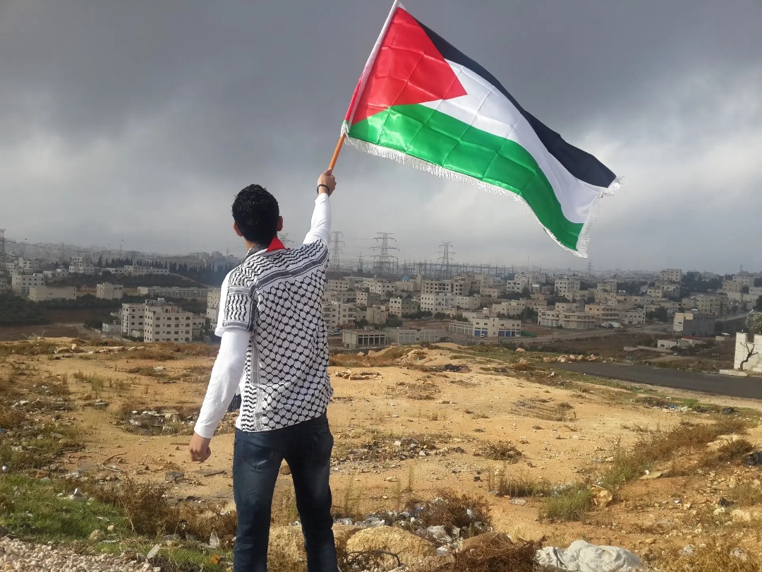 A man holding a flag of palestine