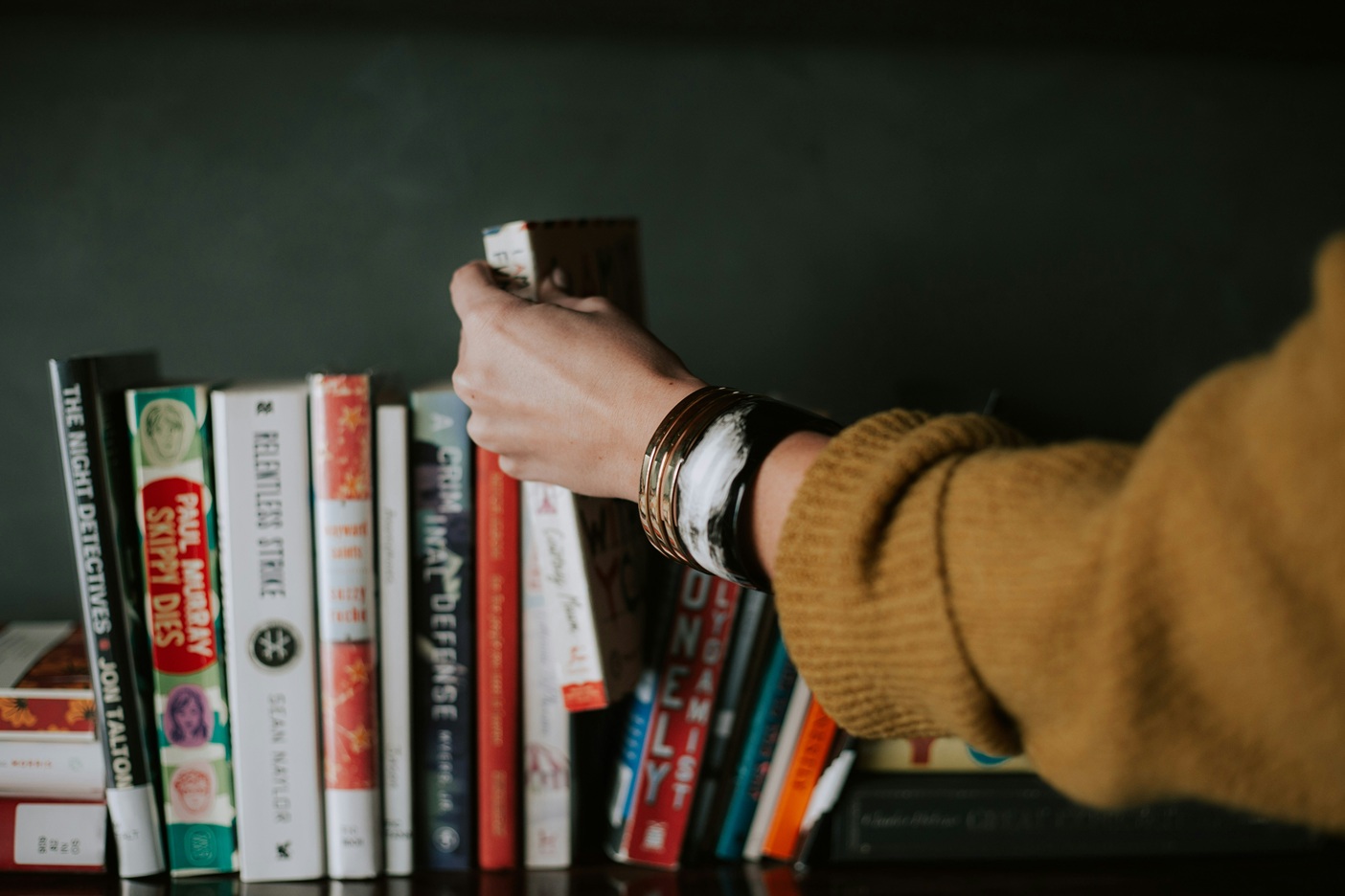 Hands picking a book