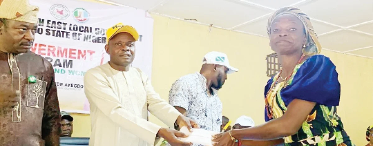 Chairman of Akoko South-East Local Government Area of Ondo State, Omolehin Ayegbo (second left), presenting N100,000 cash to one of the beneficiaries of the empowerment programme, organised for youths and women, in Isua-Akoko Ondo State. With them are government officials. Photo: Hakeem Gbadamosi